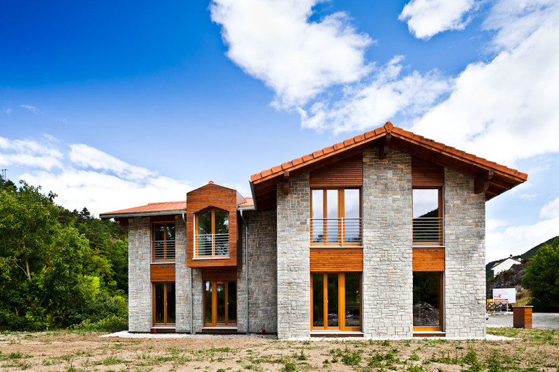 Casa Arias en Navarra, certificada con Passivhaus en 2012 con fachada de piedra y madera.