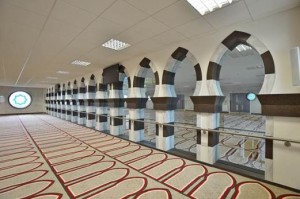 El principal espacio de oración de la nueva mezquita Jamia Sultania en Brierfield. Elevado, el espacio de rezo de las mujeres está separado por arcos hechos en DuPont ™ Corian ® en colores Cocoa Brown y Arrowroot por M y LSolid Surfaces. Foto cortesía de CD (R.U.) Ltd, todos los derechos reservados.